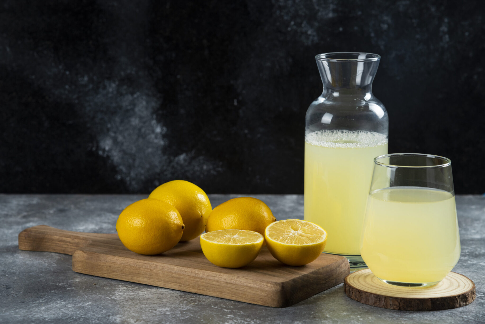 A cup of fresh lemon juice on a wooden board. High quality photo