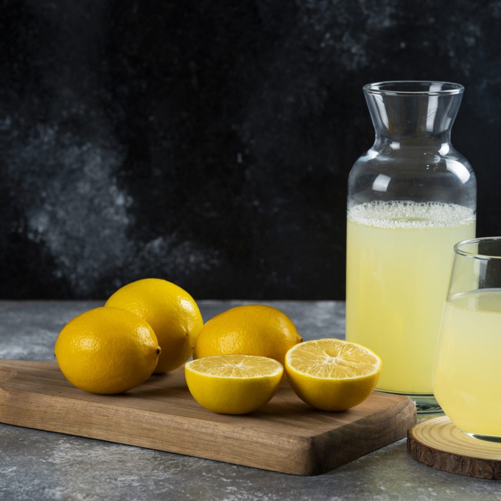A cup of fresh lemon juice on a wooden board. High quality photo